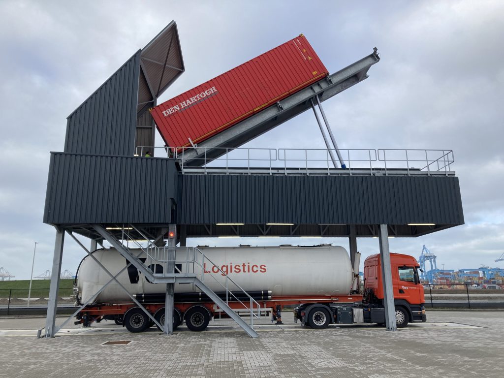 Elevated container tipping station unloading a 40ft container above a silo truck at Maasvlakte, Port of Rotterdam, with galvanized tipping table and integrated safety sensors.