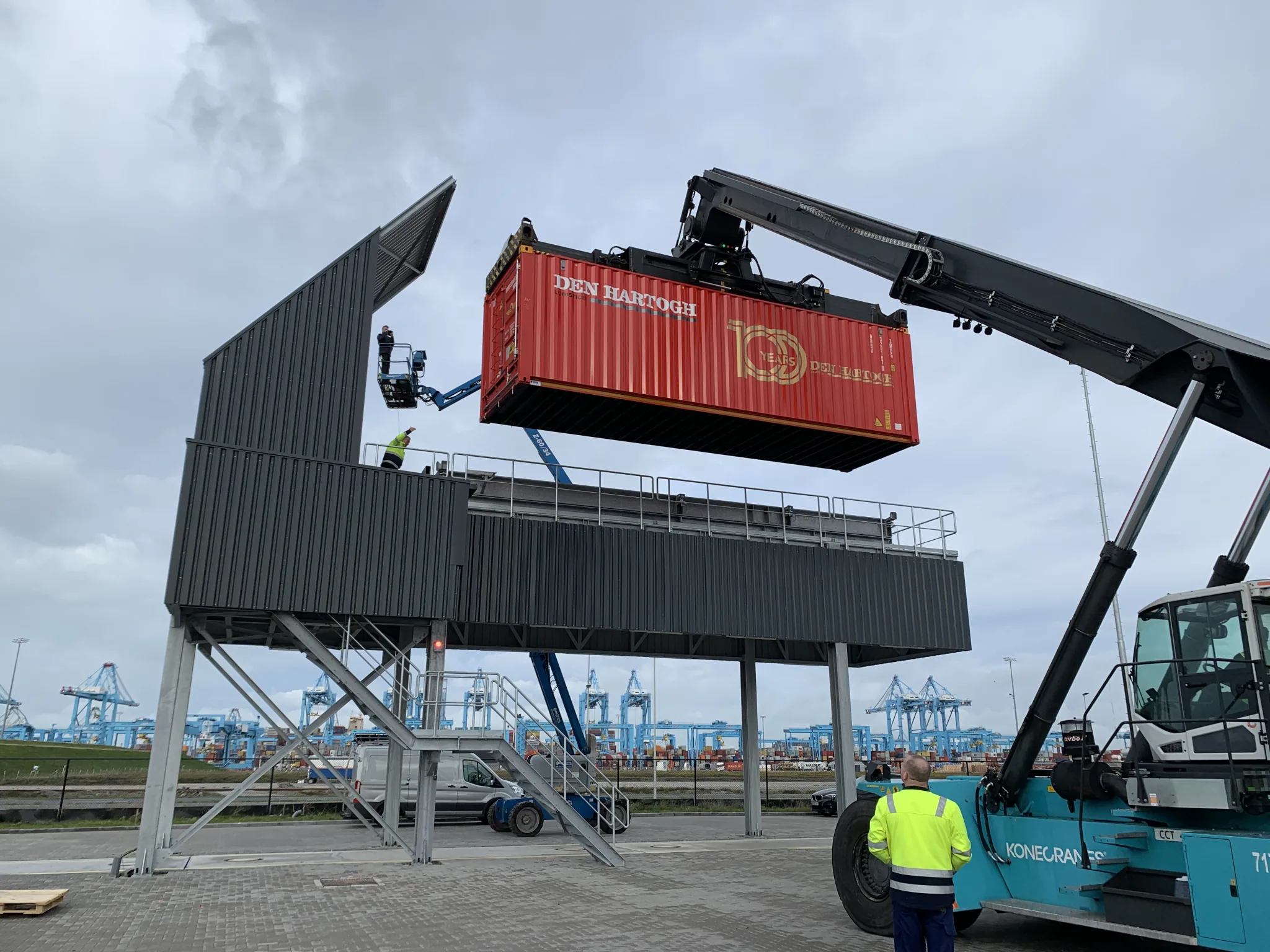 Reach stacker positioning a red shipping container at the VAKO elevated tipping station.